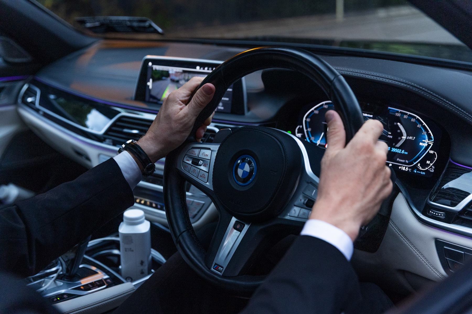Chauffeur's hands on the steering wheel of the BMW while driving