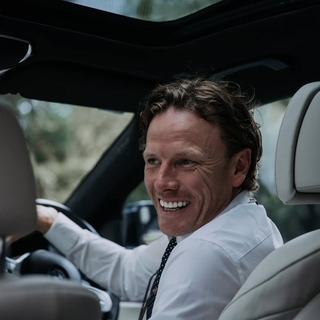 Professional chauffeur seated at the wheel of the BMW 745Le before a VIP journey